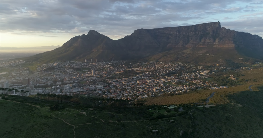 Aerial shot of a modern city under amazing mountain at dusk, drone staying still - Cape Town, South Africa
