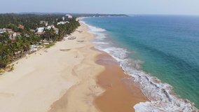 Sri Lanka tropical beach with palm trees, aerial view. Flying on a drone over the city. Sunny weather. Sri Lanka. Drone footage.