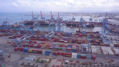 HAIFA, ISRAEL - April 5, 2020: Aerial footage of Haifa Port, docking vessels on the platform, containers and rows of imported new cars.