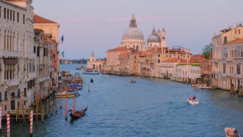 Panorama of Venice Grand Canal with boats and Santa Maria della Salute church on sunset from Ponte dell'Accademia bridge. Venice, Italy. Camera zoom in