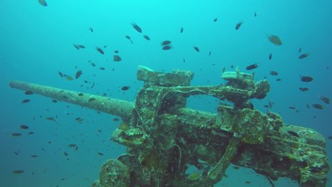 Technical wreck marine scuba diving. Old rusty wartime naval army wreckage remains on the sea bottom. Diver exploring nautical historic world war military shipwreck ruins deep under water in ocean