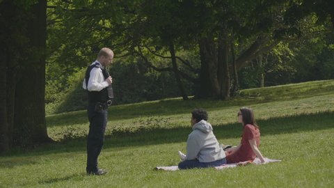 Alexandra Palace, London / UK - April 26 20: Police man breaks up social gathering picnic at Alexandra Palace Park during the Coronavirus Lockdown, London.