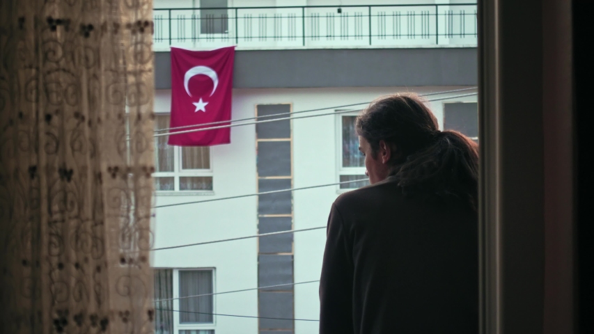 Worried millennial teen with long hair watching the empty street with Turkish flag on the background | Shutterstock HD Video #1051336900