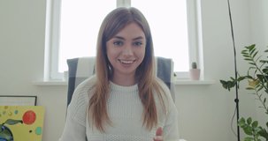 Smiling young woman working at home. Girl speaking looking at camera talking making video chat or conference call. Happy female holding tablet computer, 4k webcam view slow motion