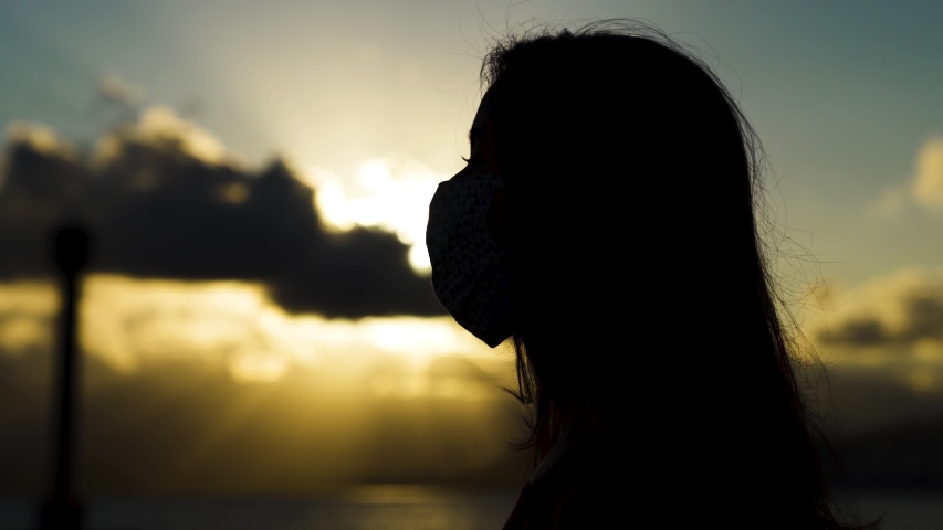 silhouete Hopeful woman wearing mask against corona virus take deep breath while take off mask due quarantine fatigue
 Royalty-Free Stock Footage #1051346023