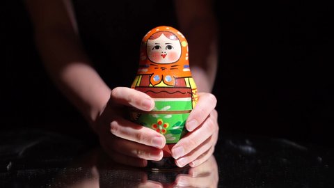 This video shows anonymous hands opening up colorful nesting matryoshka Russian folk art dolls.