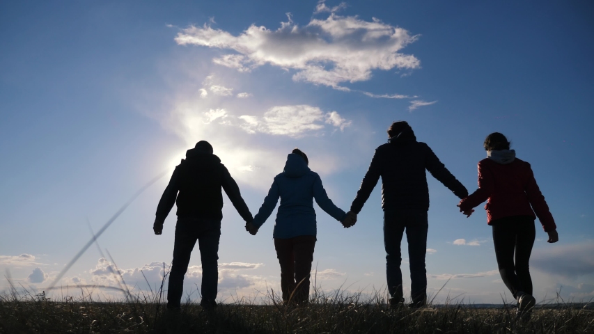 happy family and dog silhouette walking at sunset teamwork. group of people friends walking holding hands slow motion video. Happy family party and pet teamwork concept lifestyle Royalty-Free Stock Footage #1051376839