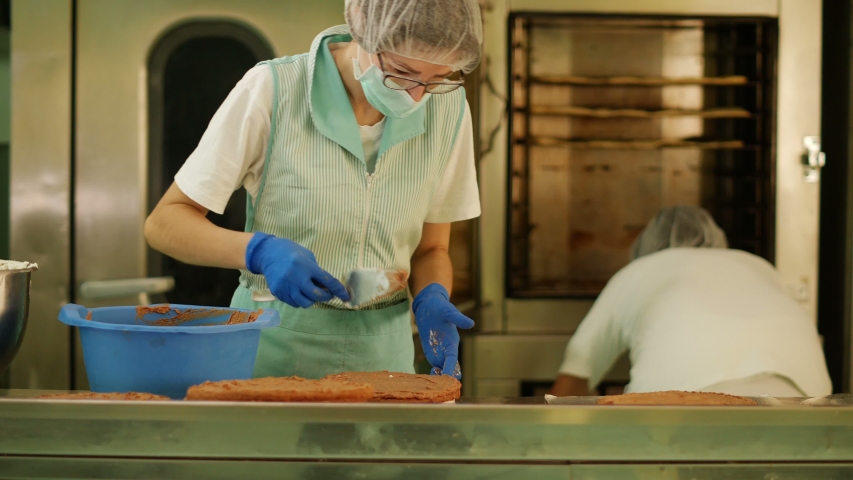 Females working in a commercial kitchen wearing protective gloves and mask Royalty-Free Stock Footage #1051384579