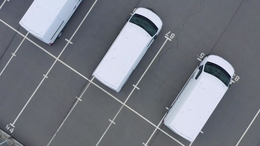 Aerial top down view of the dealership or customs terminal parking lot with a rows of new minibus Royalty-Free Stock Footage #1051385761