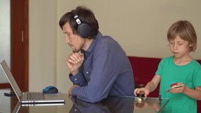 During quarantine man is trying to work remotely from home, but his son disturbes him. Children and parents conflicts during self-isolation - Powered by Shutterstock - Get 15% off with code: PIKWIZARD15