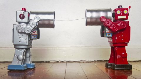 two retro robots on old tin can can phones	

