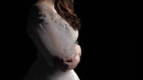 woman figure in white wedding dress hand with transparent sleeve and long loose curly hair in darkness slow motion closeup