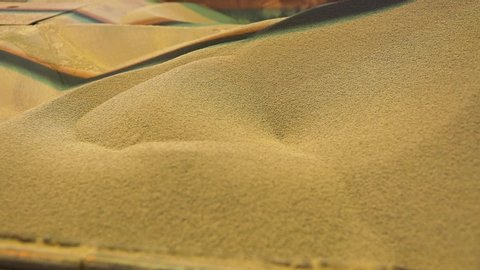Close-up of loose material in factory. Stock footage. Processing of raw additives in bulk form on sifting conveyor of plant. Large amount of white bulk material at raw material processing plant