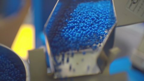 technological process. modern production.fragment of working production equipment. Processing of polymeric materials. movement of blue plastic granules in production equipment.closeup.