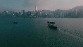 Aerial video of Hong Kong waterfront, Star Ferry Piers and Victoria Harbour at sunset