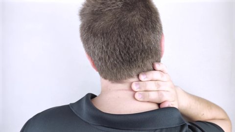 A man suffers from pain in the neck, massages the cervical spine with his hand. Osteochondrosis, hernia, or nerve injury due to sedentary work or physical stress