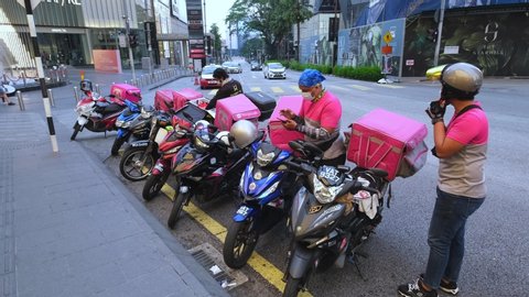 KUALA LUMPUR, MALAYSIA - APRIL 19, 2020: Food delivery service rider using motorcycle. Food delivery service through its mobile application.