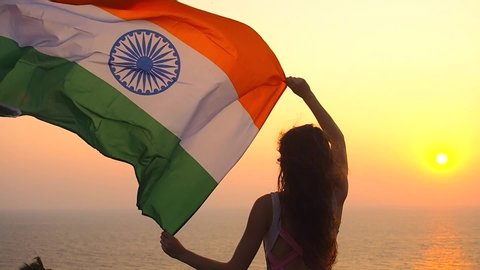 patriotism, independence day August 15 and holidays concept.back side of young woman with national indian flag on hill top of mountain