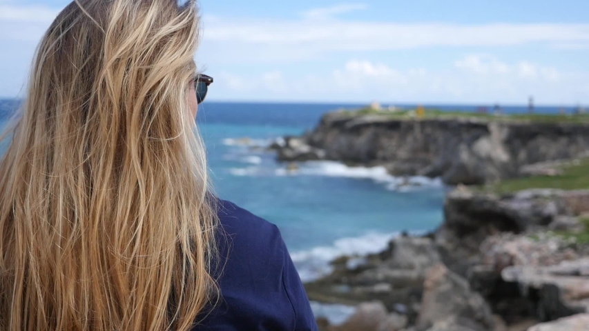 Young woman staring at the ocean in Isla Mujeres Mexico