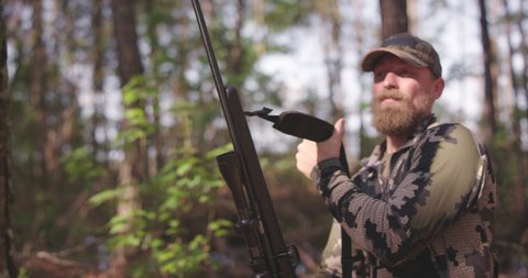 Man hunting in woods with rifle