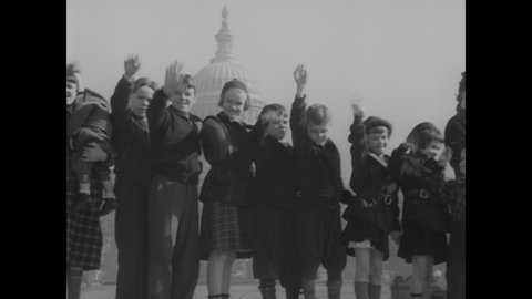 CIRCA 1938 - A large family of children gets out of cars in Washington DC to pose in front of the Capitol Building.