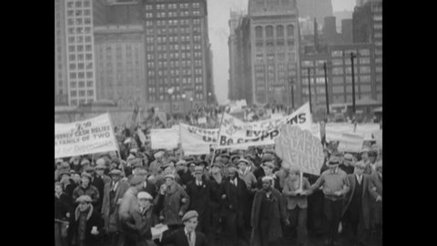 CIRCA 1932 - At a rally led by communist agitators in Chicago, Illinois, crowds protest the impending reduction of municipal support for the needy.