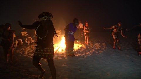 WEST AFRICA - CIRCA 2010s - African tribal dancers dance to drum rhythms in front of a bon fire in West Africa.