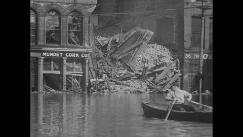 CIRCA 1933 - People in rowboats deliver supplies to others in the flooded city of Cincinnati, Ohio.