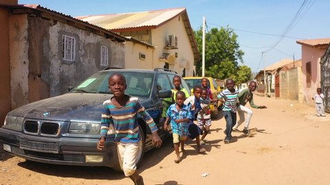 WEST AFRICA - CIRCA 2010s - Children run in slow motion on a dirt road in West Africa.