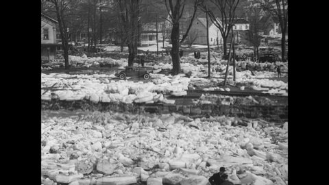 CIRCA 1934 - A neighborhood is seen covered in blocks of ice, and dynamite is used to blow up some clumps of it.