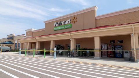 Fort Myers, FL / USA - 4/29/20:  neighborhood Walmart enforcing social distancing guidelines amid Covid-19 coronavirus pandemic Many wearing masks to protect themselves and others against the virus. 