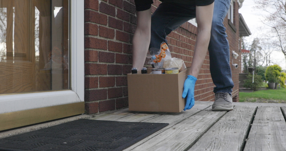 Grocery Delivery Service Man Delivering Groceries on Front Porch with Mask and Gloves | Shutterstock HD Video #1051452601