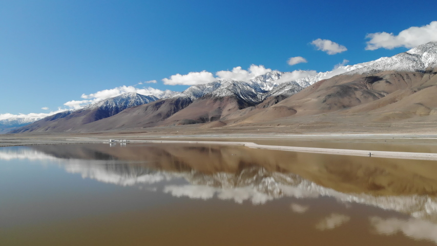 Cinematic aerial flyover of reflective Owens Lake in Eastern Sierra, California