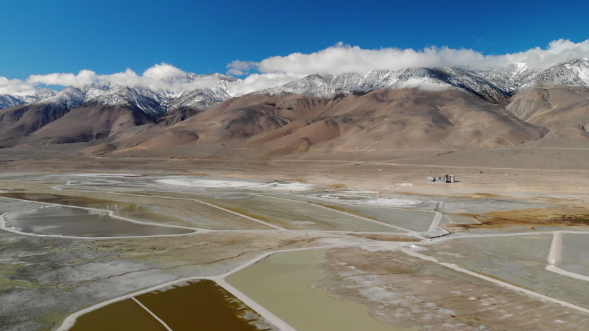 Cinematic aerial flyover of reflective Owens Lake in Eastern Sierra, California