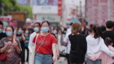 4k slow motion of blurred unrecognizable people wear face mask walking in the street city of Chengdu China crowd with mask during coronavirus Covid-19 pandemic outbreak 