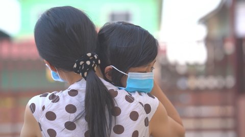 Cute child daughter hugging mother on blurred home background, kids school back to home on mather's day, Asian children and mother wearing mask protect coronavirus 19 and pm 2.5 particle in air, Thai