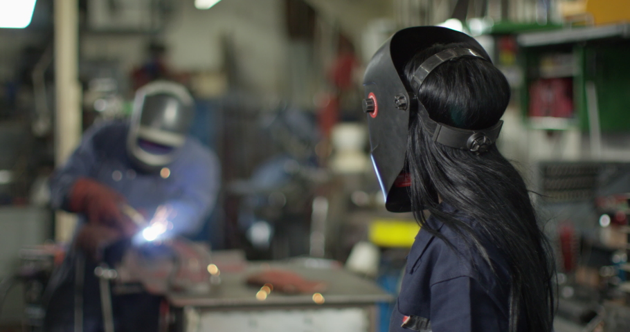 4K Portrait beautiful smiling female welder in metalwork shop. Slow motion. | Shutterstock HD Video #1051471279