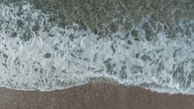 Aerial 4K video of the sustained movement of the waves on the coastline. Sea and waves concept.