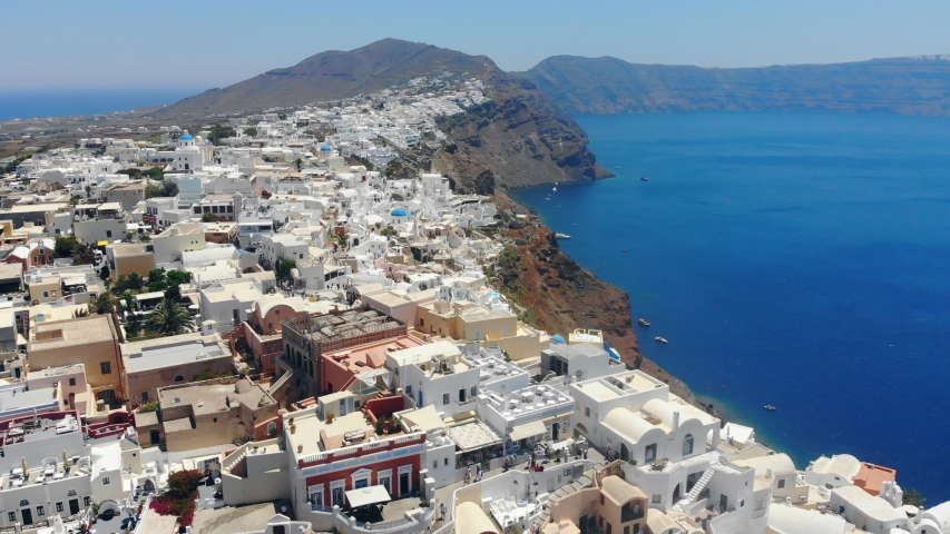 Santorini with white buildings near sea.
