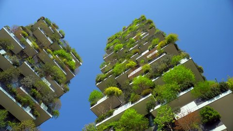 Milan, Italy, April 19, 2020: modern and ecological skyscrapers with many trees on each balcony. Bosco Verticale. Modern architecture, vertical gardens, terraces with plants. Green Planet. Blue sky