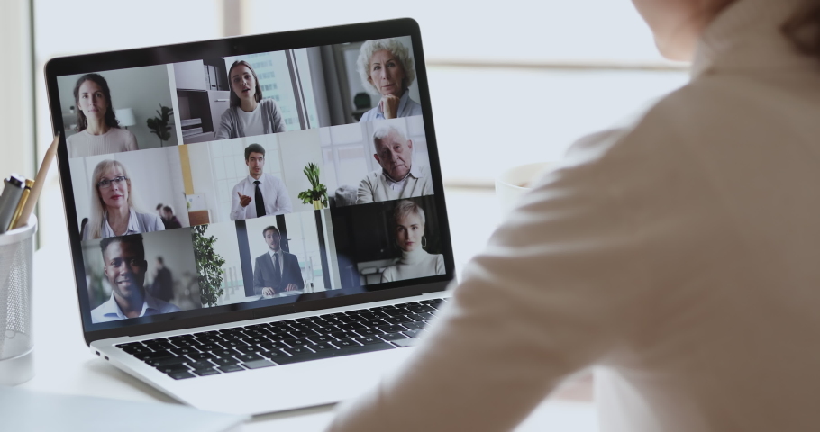 Video conference concept. Multiracial business team people communicate by web cam. Over shoulder view of distance employee at remote virtual online group meeting by video call working from home office Royalty-Free Stock Footage #1051488616