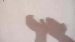 shadows of hands clapping on white wall supporting health personnel during the coronavirus, covid-19 or sars-cov-2 crisis. health concept