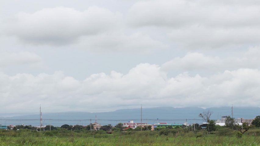Time-lapse photography, views from grassland outside the city, cloudy skies