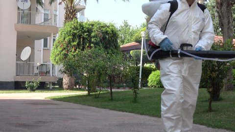 Fethiye, Turkey - 15th of April, 2020:  4K Covid-19 outbreak - Sanitary worker with a fumigator disinfects residential complex
