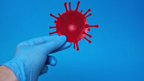 cropped view of man in latex glove holding coronavirus bacteria isolated on blue