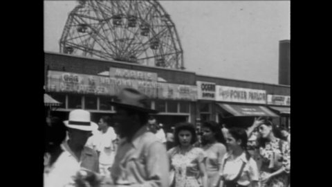 CIRCA 1945 - Black and white patrons enjoy the crowded beaches of Coney Island during the summer.