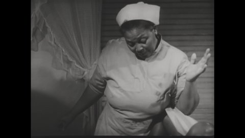 CIRCA 1952 - A midwife helps her patient laugh and relax before giving birth.
