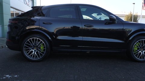 London, Middlesex / U.K. - February 16th 2020: Side view of Porsche Cayenne car in black metallic paint
