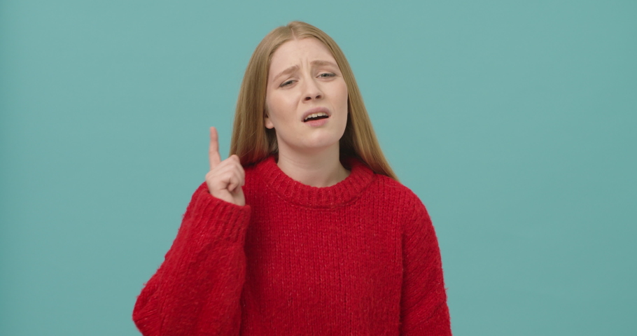 Young woman with long blond hair waving finger at the camera to warn and rebuke for misbehavior isolated over blue background. Concept of rebuke Royalty-Free Stock Footage #1051520032