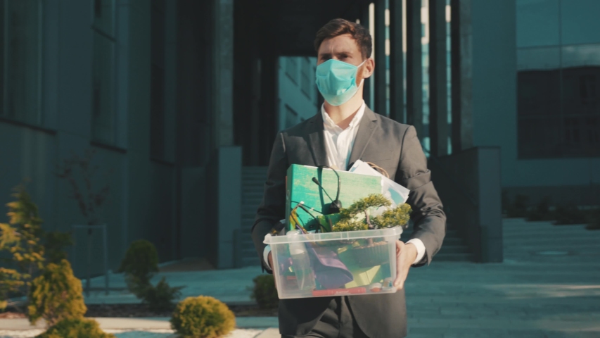 Man wear face mask walking with box of personal stuff got fired due to coronavirus crisis unemployed depression employment economy close up slow motion Royalty-Free Stock Footage #1051520992